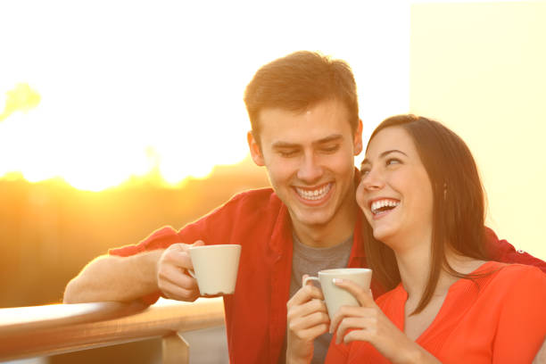 istock Happy couple enjoying coffee at sunset on a balcony 1217115476