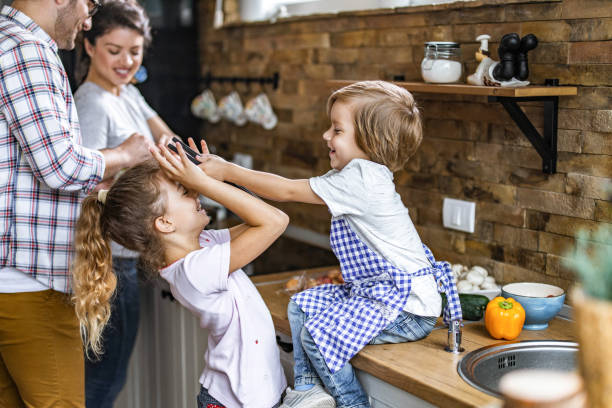 istock Young happy family having fun while preparing food in the kitchen. 1217115534