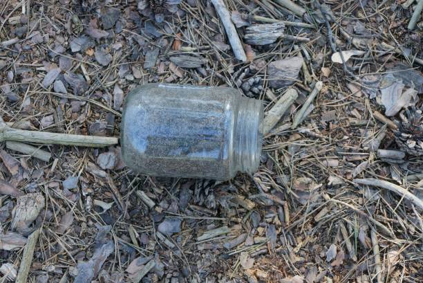 istock one dirty empty glass jar lies on dry grass 1217115893