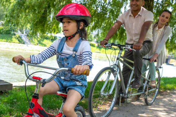 istock Family riding bicycles in park 1217118375