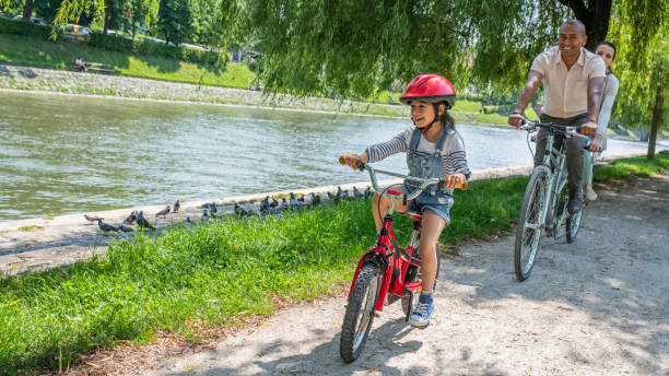 istock Family riding bicycles in park 1217118414