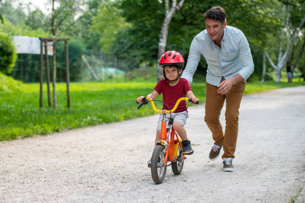 istock Father teaching his son to ride bicycle 1217118420