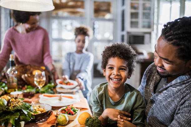 istock Happy black boy with his father at dining table. 1217119096