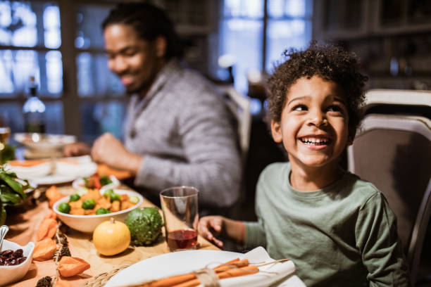 istock Happy black boy having a meal with his father at dining table. 1217120055