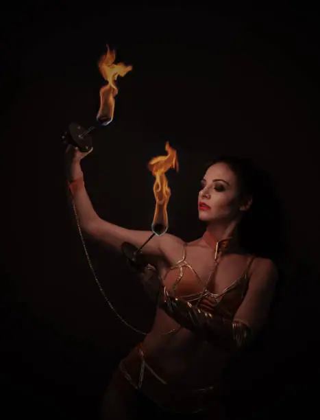 juggler girl performing fire games with python snake dress