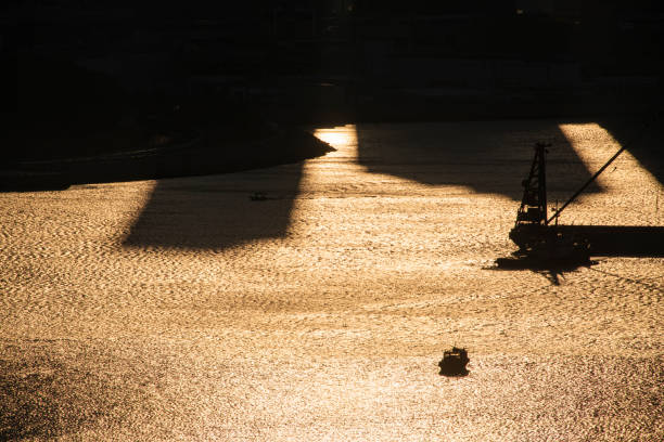 Silhouette of a boat and a barge on the sea at sunset