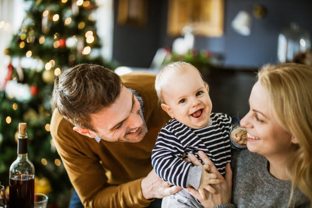 Young happy parents and their baby son during New Year at home. Happy parents having fun with their baby boy during New Year's day at home. baby new years eve new years day new year stock pictures, royalty-free photos & images