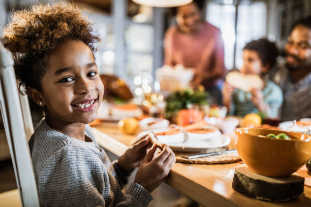 istock Happy black girl at dining table. 1217122312