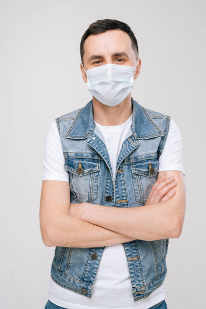 istock Young man in medical mask posing with chest hands on white background 1217122913