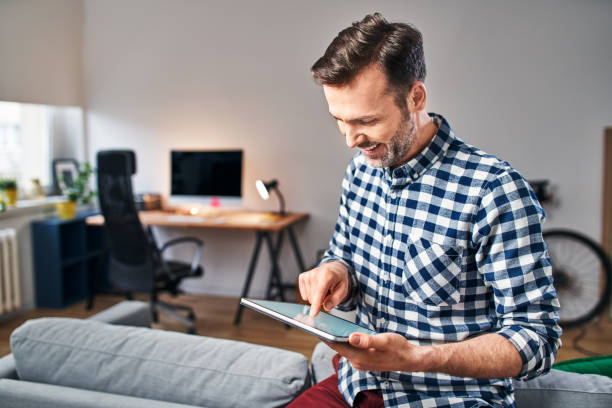 istock Happy adult man using digital tablet while working from home office 1217124397