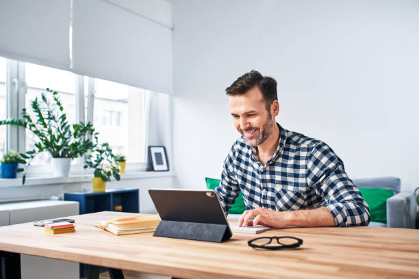 istock Freelancer working from home sitting at desk with digital tablet 1217124662