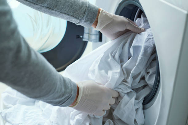 istock man putting clothes into the washing machine 1217126540