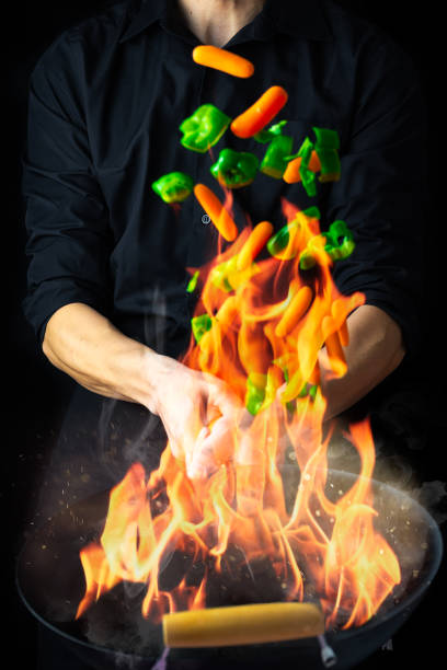 istock Chef with wok sauteing and flaming vegetables 1217128924