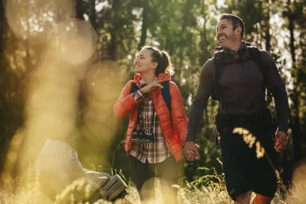 Photo of Couple going to their camping site in forest