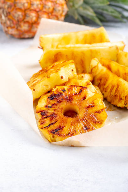 istock Heap of grilled pineapple slices on white background. 1217131837