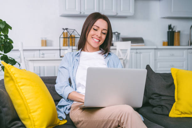 istock Young freelancer girl working home on her laptop sitting on comfortable sofa, quarantine, self isolation concept 1217132093