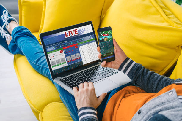 istock Cropped shot of a man lying on sofa making bets online at bookmaker's website using laptop 1217132681