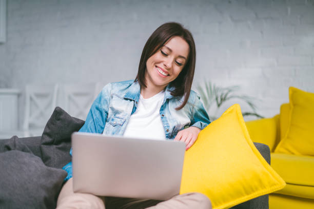 istock Young freelancer girl working home on her laptop sitting on comfortable sofa, quarantine, self isolation concept 1217132878