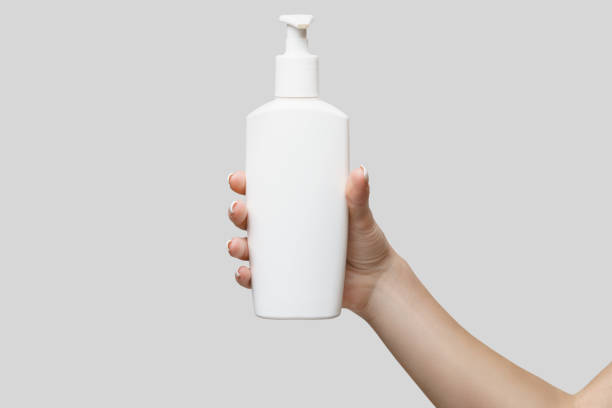 istock Female hands using hand sanitizer gel or liquid soap dispenser over light grey background 1217137526