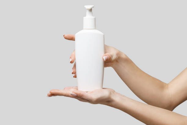 istock Female hands using hand sanitizer gel or liquid soap dispenser over light grey background 1217137563