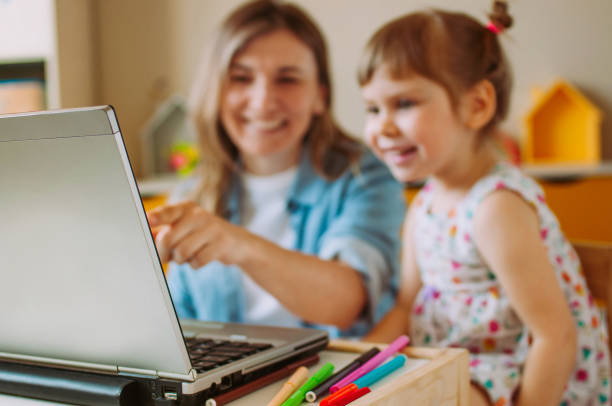 istock Smiling mother and toddler daughter looking at the notebook 1217139876