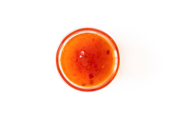 Sweet chili sauce in glass bowl isolated on white background, above. Seasoning and dip stock photo