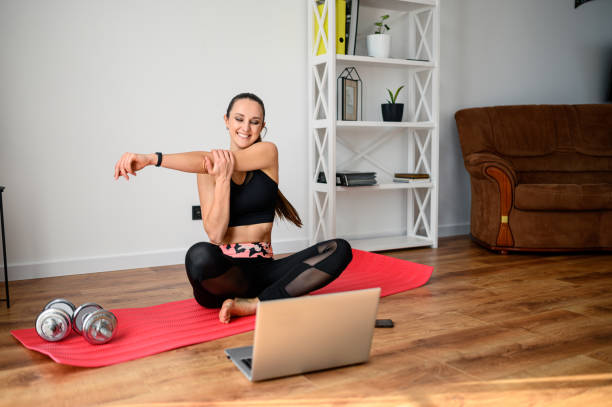 istock Woman doing fitness at home with video tutorial 1217143459