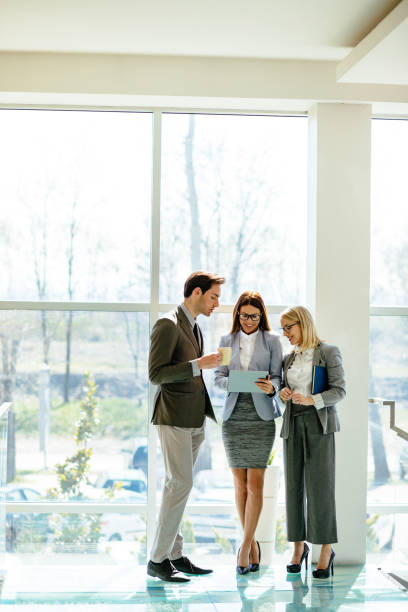 istock Business people using digital tablet in the lobby and discussing 1217143463