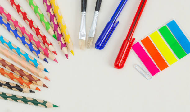 istock Colored pencils, pens and brushes on a white background with copy space. 1217143579