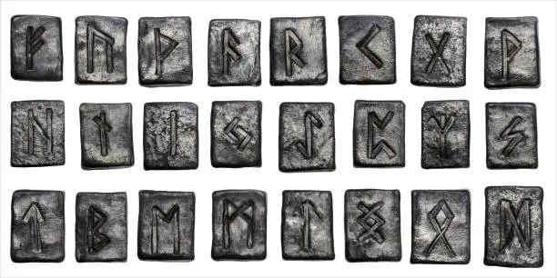 Photo of 24 black pottery Norse runes isolated on white background