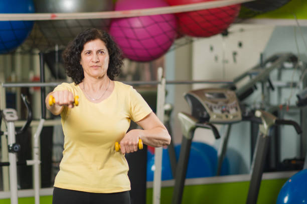 istock Mature woman exercising at gym 1217145524
