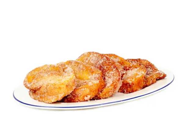 Photo of closeup of a plate with torrijas isolated on white background. Typical spanish dessert for Lent and Easter.