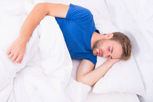 istock Seeing a dream. Sexy handsome man sleeping and having dream in bed alone. Early morning dream. Enjoying dream time 1217148470