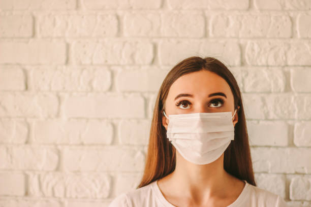 istock Girl in medical face mask looking at copy space 1217149070