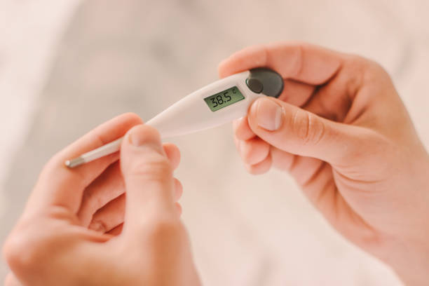 istock Man holding digital thermometer with high fever body temperature 1217150201