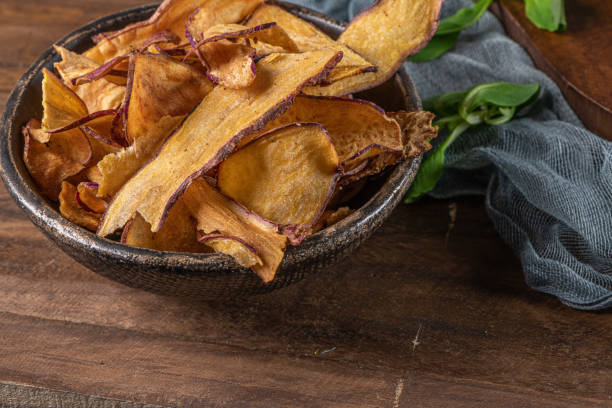 istock Delicious sweet potato chips in bowl, on table. 1217151137