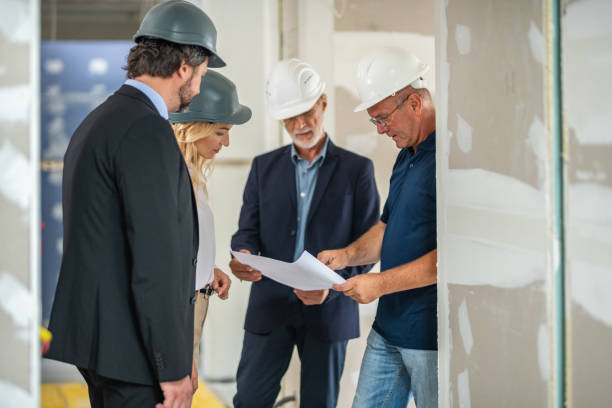 istock Architect and supervisor discussing blueprint with investors 1217153129