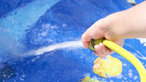 istock Filling Inflatable pool with water from hose in garden 1217153177
