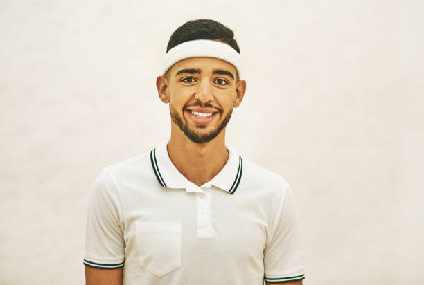 I'm no stranger to the squash court Shot of a confident young man standing on a squash court sweat band stock pictures, royalty-free photos & images