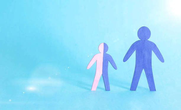 Figures of father and son on a blue background. The concept of a single father raising a child without a mother, child allowance. Inferior family, copy space Figures of father and son on a blue background. The concept of a single father raising a child without a mother, child allowance. Inferior family, copy space, guardianship divorcee stock pictures, royalty-free photos & images