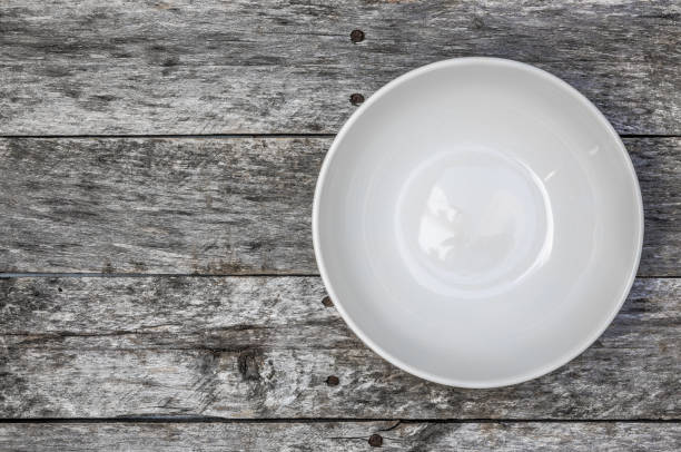 istock Empty bowl on gray wood top view 1217154103