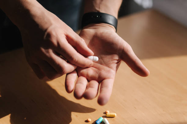 istock Many multi-colored pills on male's hands. Man with watch on hand. Coronavirus concept 1217155638
