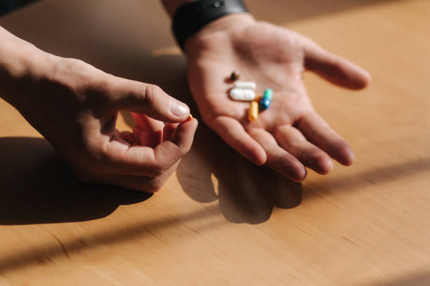 istock Many multi-colored pills on male's hands. Man with watch on hand. Coronavirus concept 1217155659