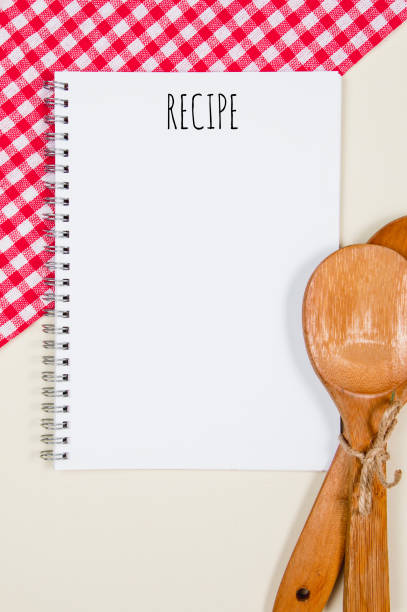 Wooden tied spoons with blank notebook page on a table