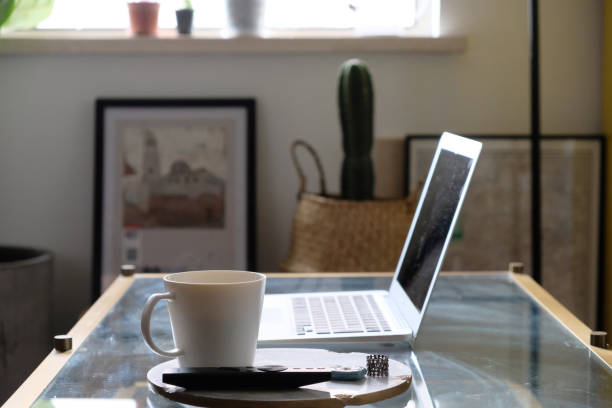 istock close up coffee mug on table. blur laptop computer and home decorations. working at home concept 1217156932