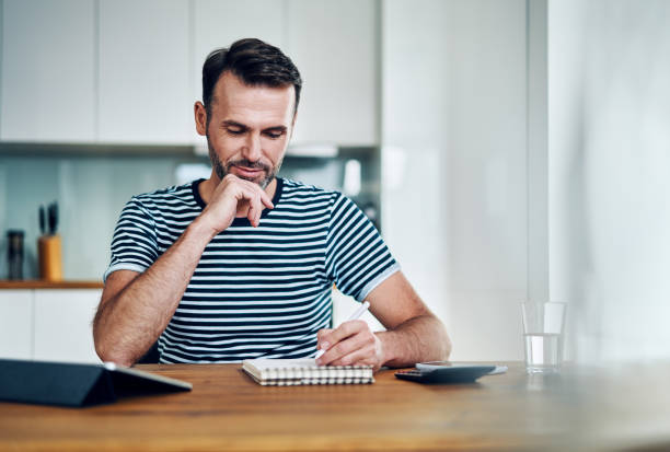 istock Happy man managing personal finance while sitting at home 1217157028
