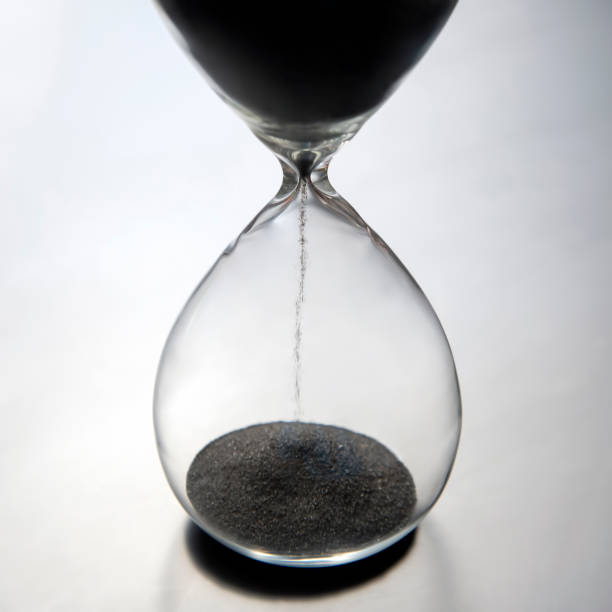 istock Hourglass on a light background. Time is money. Business solutions in time. 1217158442