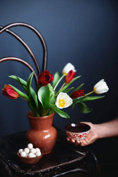 man holding ethnic bowl with tea near beautiful bouquet of tulips and kurt balls - 3621 imagens e fotografias de stock