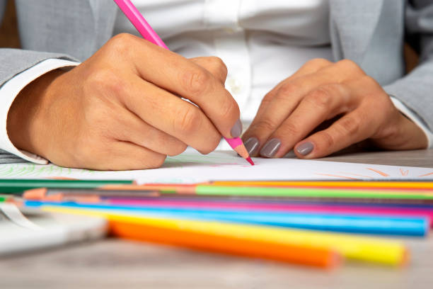 istock woman's hand in the office draws with crayons on paper 1217160095