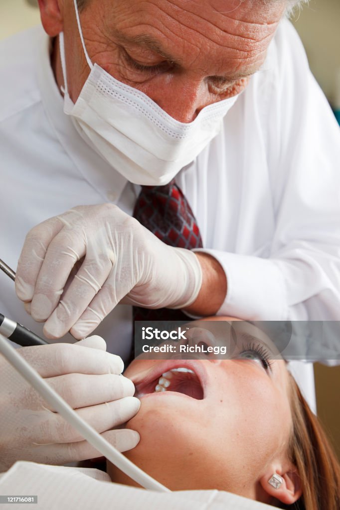 Dental Patient A dental patient having her teeth worked on by the dentist. Exodontics Stock Photo